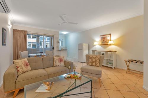 a living room with a couch and a table at The Newport on Macrossan - Adults Only in Port Douglas