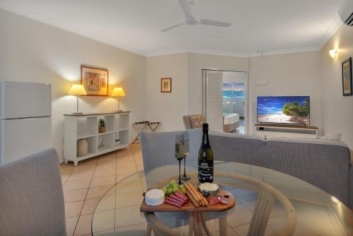 a living room with a table with a bottle of wine at The Newport on Macrossan - Adults Only in Port Douglas