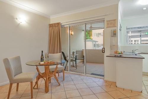 a kitchen and dining room with a table and chairs at The Newport on Macrossan - Adults Only in Port Douglas