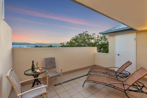 a balcony with chairs and a table with a view at The Newport on Macrossan - Adults Only in Port Douglas