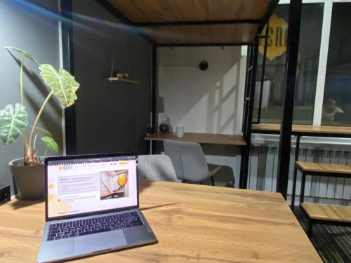 a laptop computer sitting on top of a wooden table at Flats Hostel in Astana