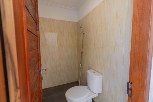 a bathroom with a white toilet in a room at Seven Angels Villa and Hostel in Nusa Penida