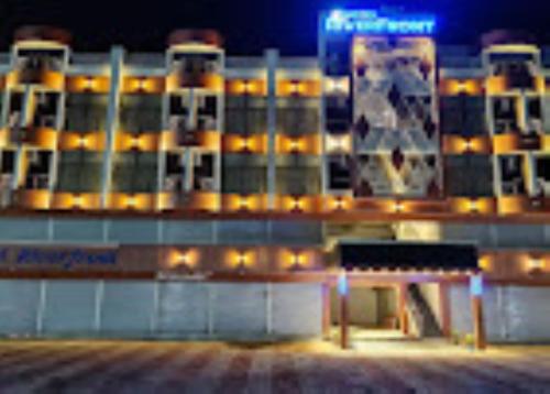 un grand bâtiment avec des lumières devant lui dans l'établissement Hotel Riverfront , Prabhas Patan, à Somnath