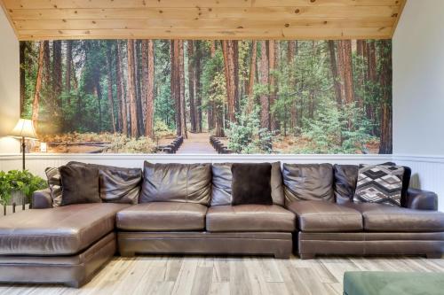 a leather couch in a living room with a painting of a forest at Soose Manor Spa BBQ Games and Bar Near Lake in Tafton