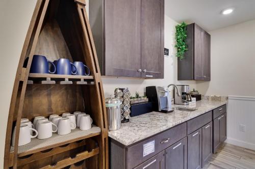 a kitchen with wooden cabinets and a counter with mugs at Soose Manor Spa BBQ Games and Bar Near Lake in Tafton