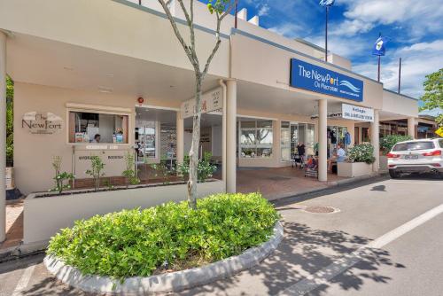 a building with a tree in front of a street at The Newport on Macrossan - Adults Only in Port Douglas