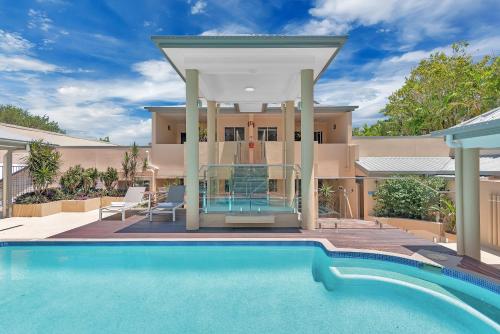 a house with a swimming pool in front of a house at The Newport on Macrossan - Adults Only in Port Douglas
