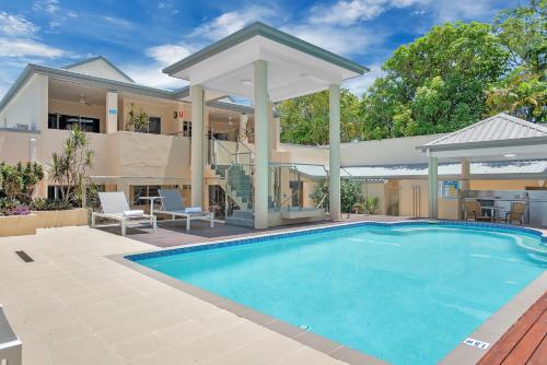 a swimming pool in front of a house with a gazebo at The Newport on Macrossan - Adults Only in Port Douglas