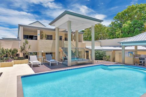 a swimming pool in front of a house at The Newport on Macrossan - Adults Only in Port Douglas