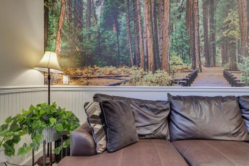 a couch in a living room with a picture of a forest at Soose Manor Spa BBQ Games and Bar Near Lake in Tafton
