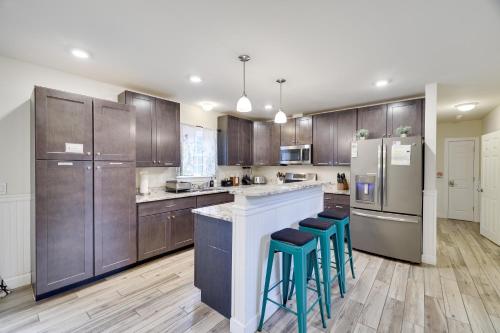 a kitchen with wooden cabinets and a bar with stools at Soose Manor Spa BBQ Games and Bar Near Lake in Tafton