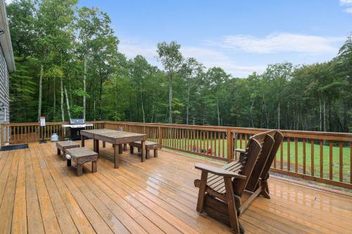 a wooden deck with a picnic table and chairs on it at Soose Manor Spa BBQ Games and Bar Near Lake in Tafton