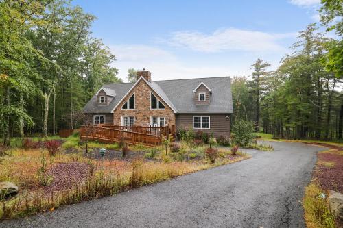 a house in the woods with a driveway at Soose Manor Spa BBQ Games and Bar Near Lake in Tafton