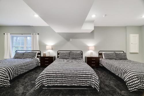 a bedroom with two beds with black and white sheets at Soose Manor Spa BBQ Games and Bar Near Lake in Tafton