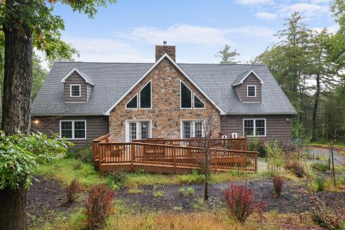 a house with a large wooden deck in front of it at Soose Manor Spa BBQ Games and Bar Near Lake in Tafton