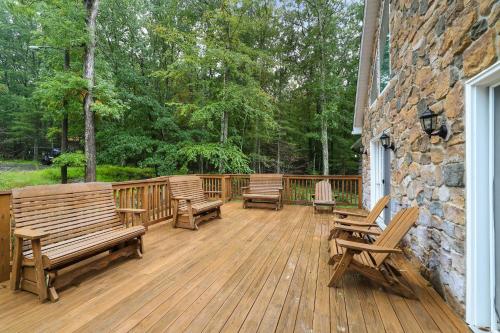 a wooden deck with benches and a stone wall at Soose Manor Spa BBQ Games and Bar Near Lake in Tafton