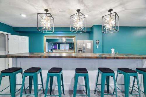 a kitchen with blue walls and a bar with stools at Soose Manor Spa BBQ Games and Bar Near Lake in Tafton
