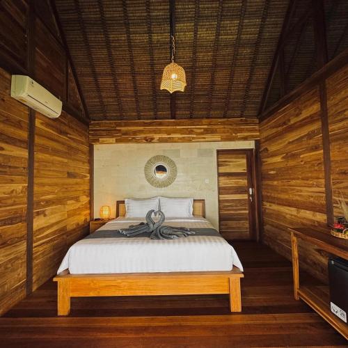 a bedroom with a bed in a room with wooden walls at Uma Pantai Seseh in Canggu