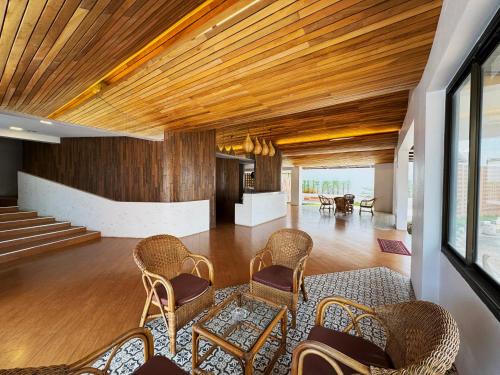 a lobby with wicker chairs and wooden ceilings at Plernpetch Hotel in Surat Thani
