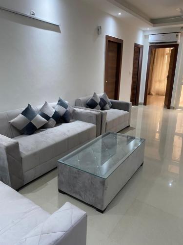 Sala de estar con 2 sofás y mesa de centro en home away from home, en Greater Noida