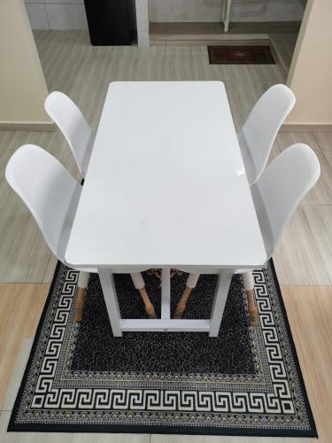 a white table and two chairs on a rug at Villa Tok Wan in Kuantan