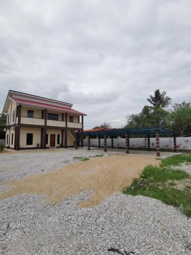 un edificio con un parque infantil delante de él en Villa Tok Wan, en Kuantan