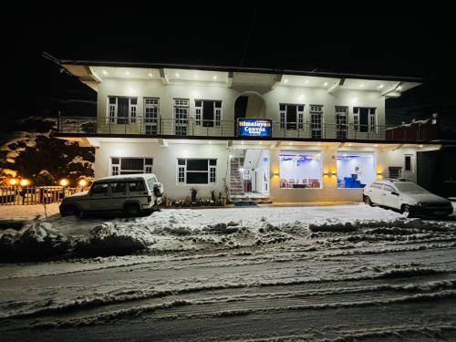 two cars parked in front of a building at night at Himalayan Canvas khajjiar in Khajjiar 