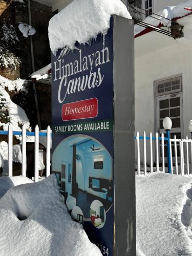 a sign in the snow in front of a fence at Himalayan Canvas khajjiar in Khajjiar 