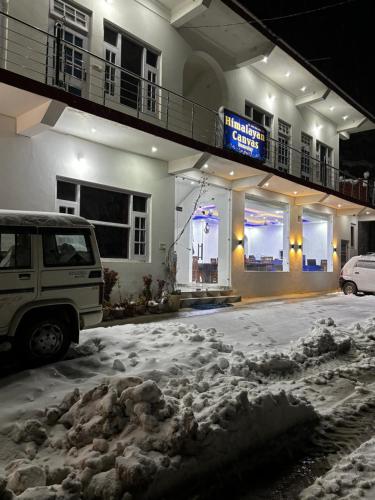 a car parked in front of a building in the snow at Himalayan Canvas khajjiar in Khajjiar 