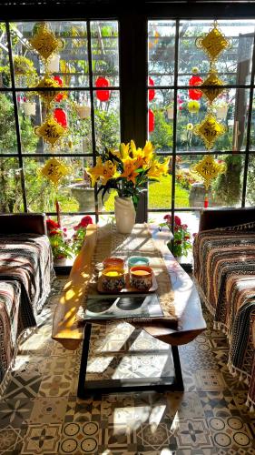 a table with two sandwiches and a vase of flowers at JE T'AIME VILLA - Khu nghỉ dưỡng nhà vườn nằm giữa thiên nhiên bao la hoa cỏ in Bao Loc