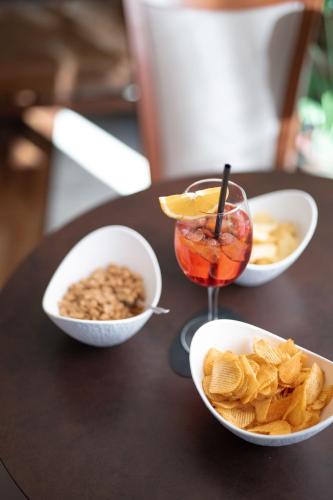 a table with bowls of snacks and a drink on it at Charme Hotel in Prato