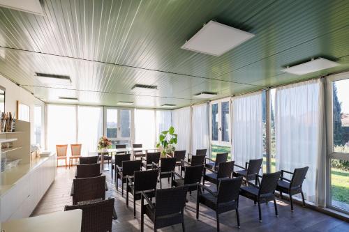 a large room with chairs and tables and windows at Charme Hotel in Prato
