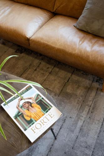a magazine sitting on a coffee table next to a couch at Charme Hotel in Prato