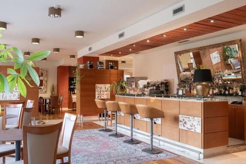 a restaurant with a bar with chairs and a mirror at Charme Hotel in Prato