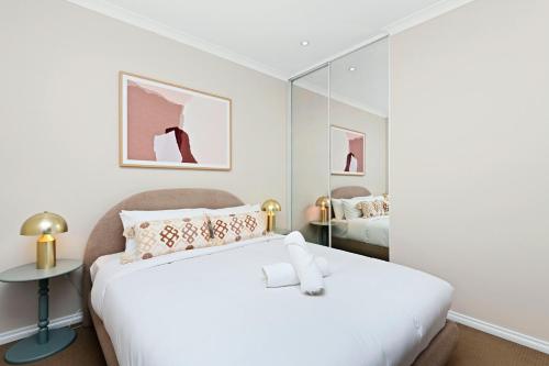 a bedroom with a white bed and a mirror at Stunning 3BR Perth Penthouse in Perth