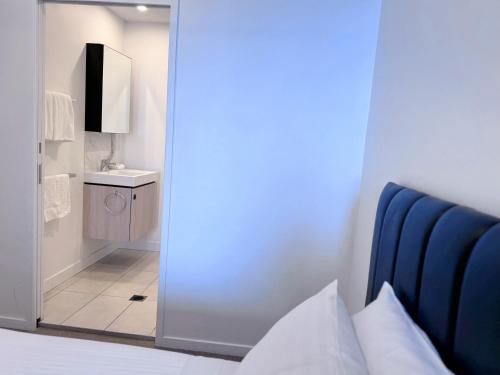 a bedroom with a door to a bathroom with a mirror at Urban Riverside Escape at Cultural Centre Precinct in Brisbane