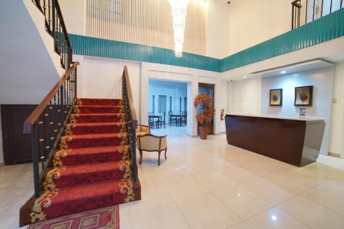 a lobby with a staircase in a building at Noola Inn Hotel Bogor in Kamparganya
