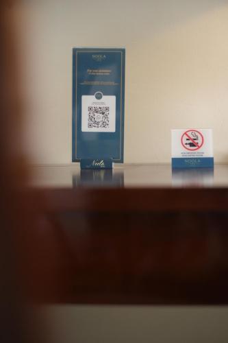 a no smoking sign and a box on a table at Noola Inn Hotel Bogor in Kamparganya
