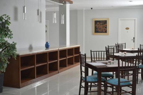 a restaurant with tables and chairs and a counter at Noola Inn Hotel Bogor in Kamparganya