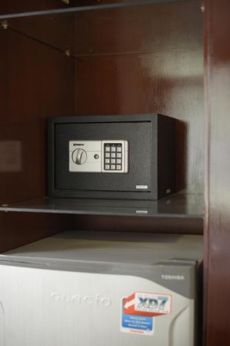 a microwave oven sitting on top of a refrigerator at Noola Inn Hotel Bogor in Kamparganya