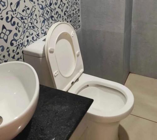 ein Badezimmer mit einem weißen WC und einem Waschbecken in der Unterkunft OYO Kailath Safe Stay Tourist Home in Thekkady