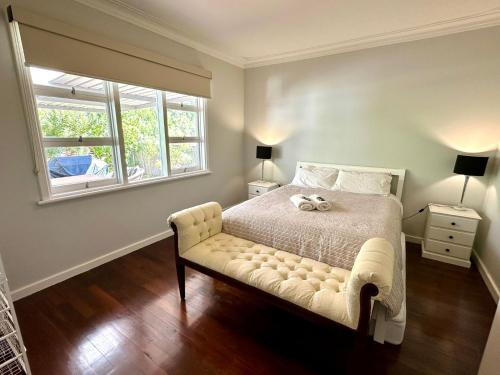 ein Schlafzimmer mit einem Bett, auf dem ein Teddybär liegt in der Unterkunft West Busselton Cottage in Broadwater