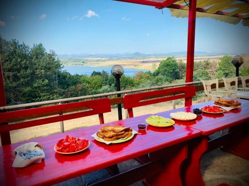 una mesa roja con platos de comida. en Хижа Манастирчето-Книжовник en Haskovo