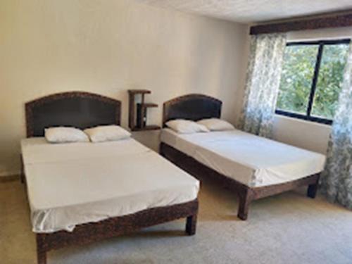 a bedroom with two beds and a window at HOTEL PALACIO in Acapulco