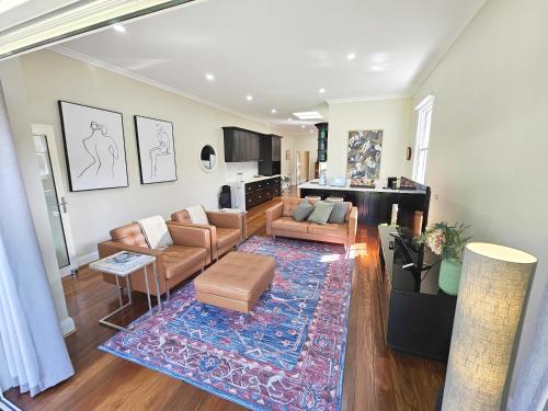 a living room with a couch and a rug at Araluen, Heart of Bowral in Bowral