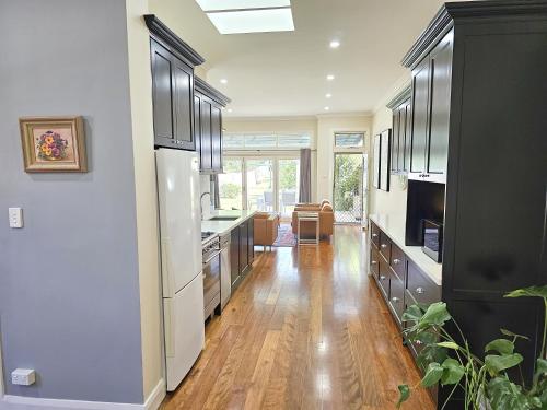 a kitchen with wooden floors and black cabinets at Araluen, Heart of Bowral in Bowral