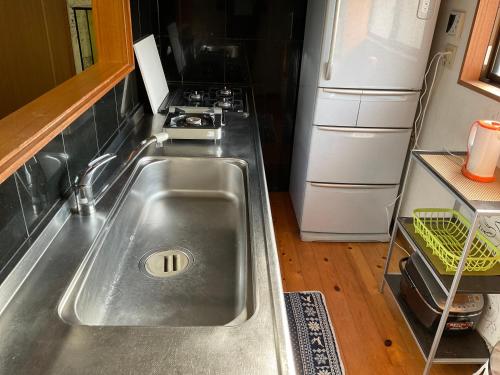 a kitchen with a sink and a refrigerator at ゆーみー. in Meinohama