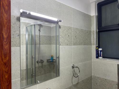 a shower with a glass door in a bathroom at Home Croft Nairobi in Nairobi