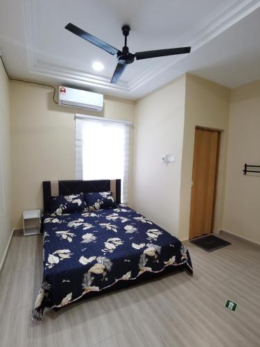 a bedroom with a bed and a ceiling fan at Roomstay Villa Tok Wan in Kuantan