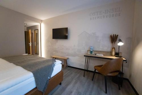 Schlafzimmer mit einem Bett, einem Schreibtisch und einem TV in der Unterkunft Oste-Hotel Superior in Bremervörde